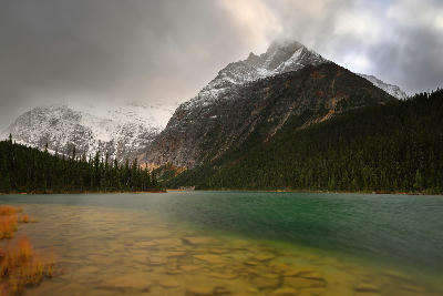 Mount Edith Cavell and Sorrow Peak above Cavell Lake under moody cloudy sky