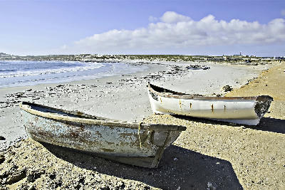 Traditional fishing boats on the sandy shoreline of Hondeklip Bay along the Atlantic coast of Namaqualand, South Africa.