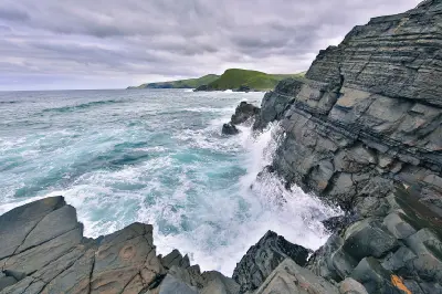 Ocean waves striking layered rock cliffs at Mapuzi on the Wild Coast of the Eastern Cape.