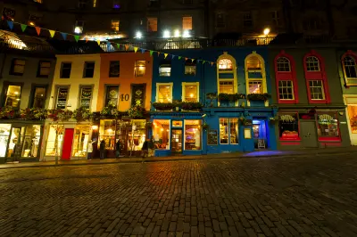 Victoria Street in Edinburgh at night with colourful buildings and cobblestones.