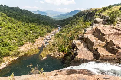 View from the edge of Berlin Falls showing the river flowing through a rocky gorge surrounded by dense vegetation in Mpumalanga.