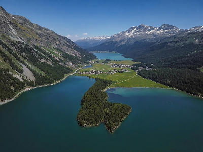 Aerial view of Lake Silvaplana and nearby alpine lakes with villages, forests, and surrounding mountains in the Engadin valley, Switzerland.