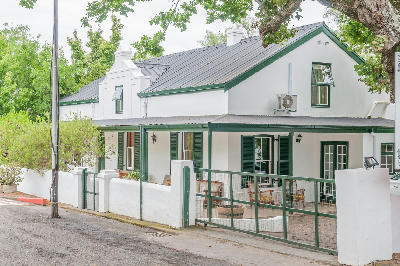 Historic Cape Dutch house and oak trees in Swellendam in the Western Cape, South Africa.