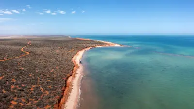 Aerial view of the red coastline, pale beach and turquoise waters of Gregories Bay in François Peron National Park.