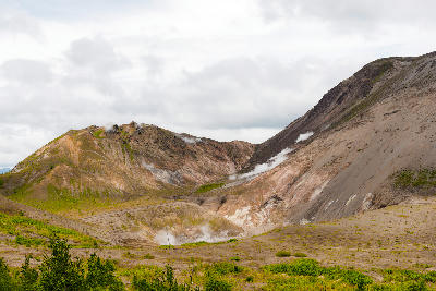 Steaming crater slopes of Mount Usu showing active volcanic vents in Hokkaido, Japan.