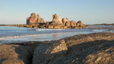 Orange lichen-covered granite formations at Picnic Rocks near Eddystone Point, Tasmania.