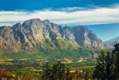 Dramatic mountain range overlooking vineyards and valley landscapes near Franschhoek in the Cape Winelands of South Africa.