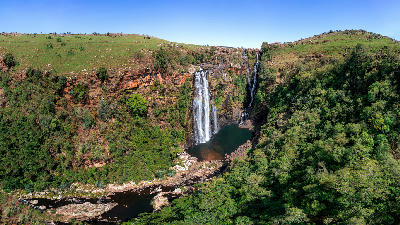 Wide view of Lisbon Falls in Mpumalanga showing the waterfall, plunge pool and forested gorge within the Panorama Route landscape.