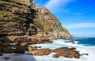 Cliffs of Cape Point rising above the shoreline as seen from Dias Beach on the Cape Peninsula in Table Mountain National Park, South Africa.