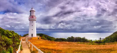 Path leading to Cape Otway Lighthouse beneath dramatic clouds overlooking the Southern Ocean, Victoria.