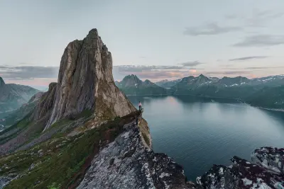 Person standing on Hesten ridge overlooking Segla mountain and fjord in Senja