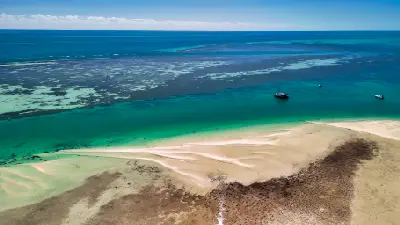 Turquoise shallows, sand flats and boats along the coast at Monkey Mia in Shark Bay.