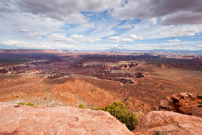 Wide view from Grand View Point showing layered canyons, mesas, and desert terrain under clouded sky in Canyonlands National Park Utah