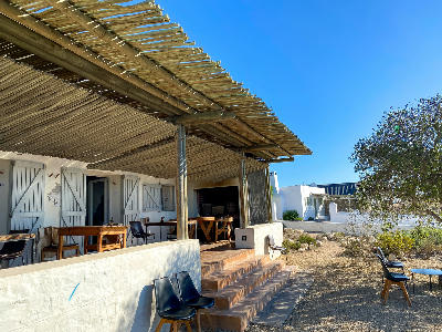 Outdoor veranda and dining area at Wolfgat Restaurant in Paternoster, featuring whitewashed walls, timber pergolas and a relaxed West Coast atmosphere.