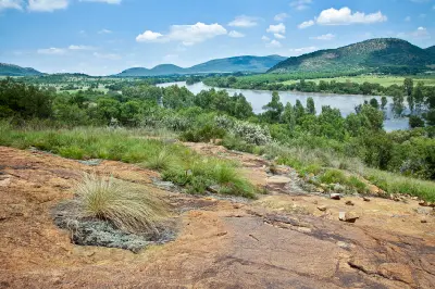 Elevated view across the Vaal River toward the wooded ridges and rocky landscapes of the Vredefort Dome in South Africa.