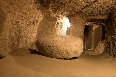Large circular stone door within a rock-cut passage in Derinkuyu Underground City, Cappadocia, Turkey.