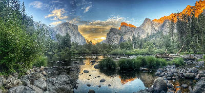 Valley View Yosemite at sunset with El Capitan and Bridalveil Fall reflected in the Merced River with warm light on granite cliffs.