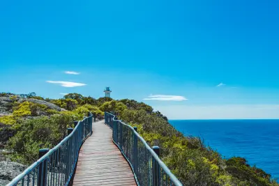 Timber boardwalk leading towards Cape Tourville Lighthouse above the Tasman Sea in Freycinet National Park, Tasmania.