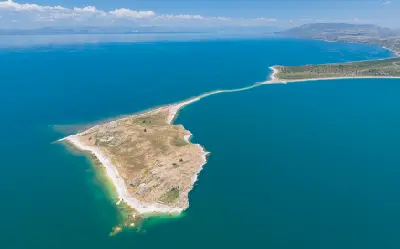 Aerial view of Çarpanak Island and historic Ktuts Monastery in the turquoise waters of Lake Van, eastern Turkey.