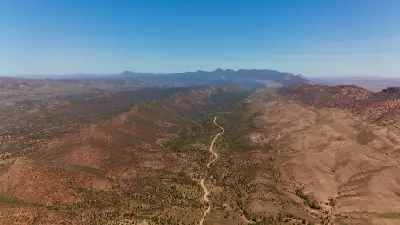 Aerial view of Brachina Gorge showing a winding dirt road through rocky outback valleys in the Flinders Ranges, South Australia.