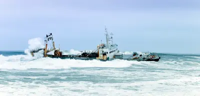 Rusting shipwreck in rough Atlantic surf along the Skeleton Coast near Cape Cross in Namibia.
