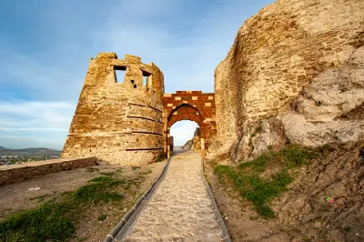 Stone entrance gate and defensive walls of historic Van Castle on its rocky ridge in eastern Turkey.