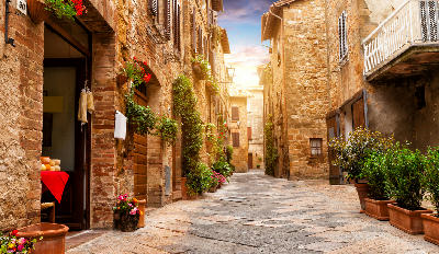 Colorful street in Pienza with many decoration flowers and trees, Tuscany, Italy