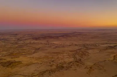 Aerial view of dry desert plains near Spitzkoppe in Namibia during soft sunrise light.
