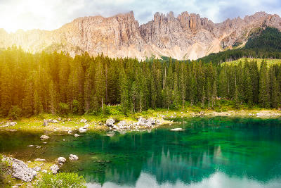 Turquoise Lago di Carezza lake with forest and Latemar mountains in the Dolomites, Italy.