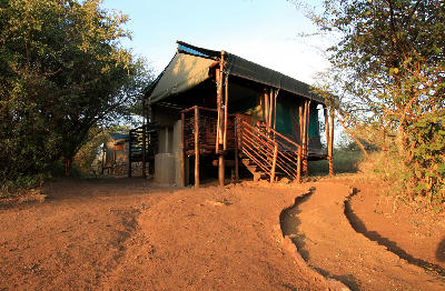 Safari tent chalet at Lower Sabie Rest Camp in Kruger National Park with wooden deck and surrounding bushveld.