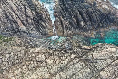 Aerial view of granite rock formations and turquoise pools at Injidup Natural Spa, Yallingup, Western Australia.