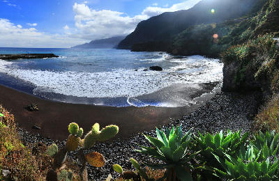 Black sand beach at Praia do Seixal on the rugged north coast of Madeira Island, Portugal.