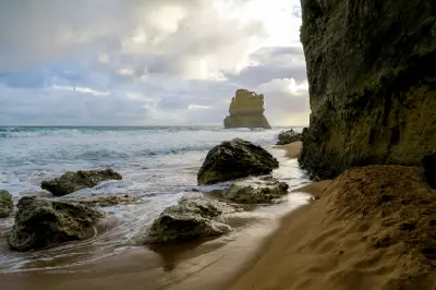 Limestone sea stack, rocks and breaking waves viewed from Gibson Steps Beach, Victoria, Australia.