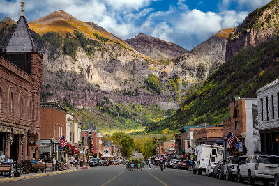 Telluride Colorado downtown street with fall colors and San Juan Mountains in the background.