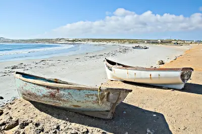 Two weathered fishing boats on the sandy beach at Hondeklip Bay along the Atlantic coast of the Northern Cape, South Africa.