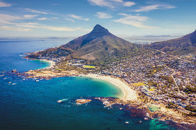 Aerial view of Camps Bay and Clifton beaches with Lion’s Head rising between the Atlantic coastline and Cape Town suburbs.