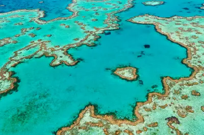 Aerial view of Heart Reef surrounded by turquoise water and extensive coral formations in the Great Barrier Reef, Queensland.