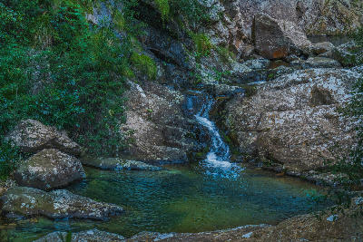 Clear mountain stream flowing through rocky pools at Rust-en-Vrede Waterfall near Oudtshoorn in the Western Cape of South Africa.