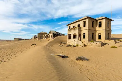 Abandoned buildings partially buried by desert sand in Kolmanskop, Namibia.