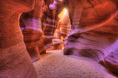 Glowing sandstone walls inside Antelope Slot Canyon near Page, Arizona, with sculpted rock curves lit by reflected sunlight.