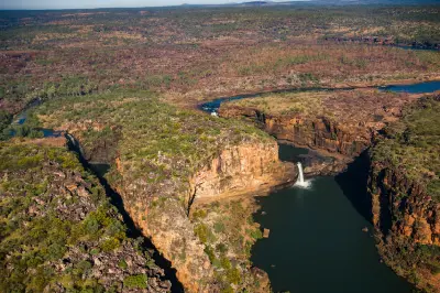 Aerial view showing Mitchell Falls and Big Mertens Falls plunging into separate deep pools between towering sandstone cliffs on the Mitchell Plateau.