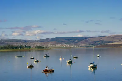 Sailing yachts moored on the still waters of Midmar Dam, with rolling hills and Midlands countryside in the background.