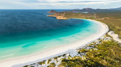 Aerial view of Lucky Bay with white sand, turquoise water, granite hills and coastal heath in Cape Le Grand National Park, Western Australia.