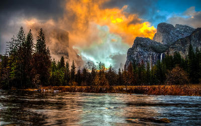 Valley View Yosemite with El Capitan in mist and Bridalveil Fall under dramatic storm clouds above the Merced River.