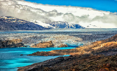 Upsala Glacier flowing into Lago Guillermo with turquoise water and rocky foreground in Patagonia near El Calafate, Argentina.