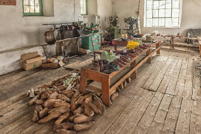 Traditional shoe lasts, handcrafted leather footwear, and historic machinery inside the old shoe factory in Wupperthal, a heritage workshop in the northern Cederberg.
