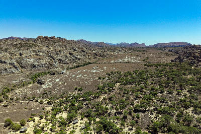 Aerial landscape of Isalo National Park in Madagascar showing sandstone plateaus, dry canyon valleys, and scattered vegetation