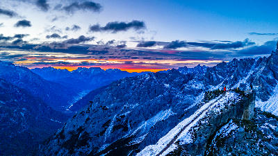 Cadini di Misurina ridge viewpoint at sunrise with hikers overlooking the Dolomite mountains, Italy.