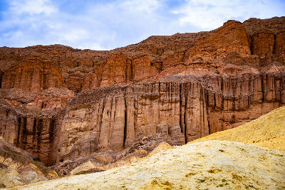 Red Cathedral banded rock cliffs above Golden Canyon layered badlands below Zabriskie Point Death Valley California