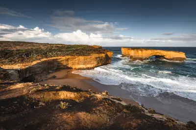 Elevated view over Loch Ard Gorge, its sheltered beach and limestone formations on Victoria’s Great Ocean Road.